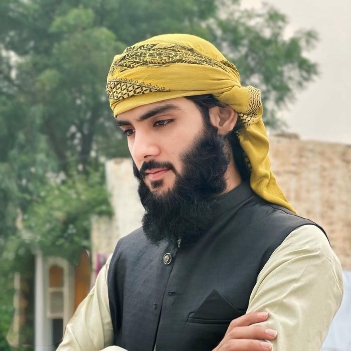 Bearded man wearing yellow headscarf looking away candidly