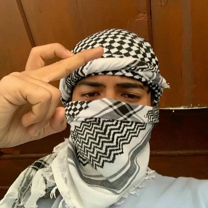 Guy taking selfie covering eyes with hand and scarf