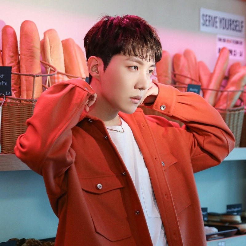 J-Hope orange jacket holding snack grocery store background view