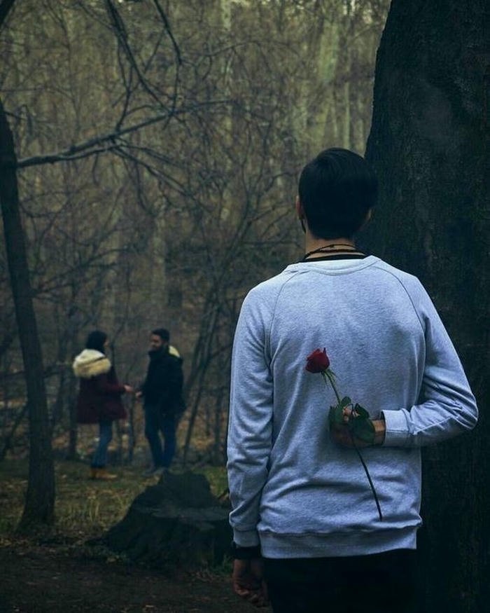 Love failure images man walking forest holding rose alone