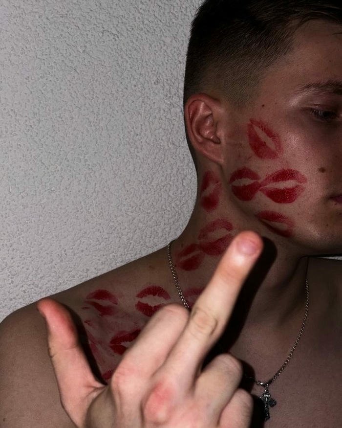 Man showing finger covered red kiss marks view