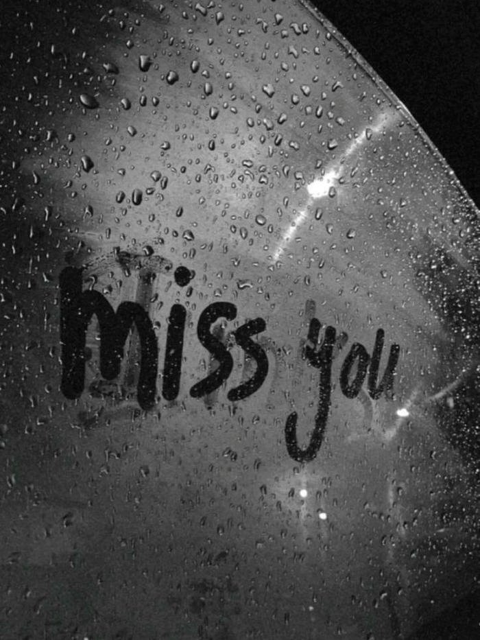 Sad love images miss you text written on wet glass window