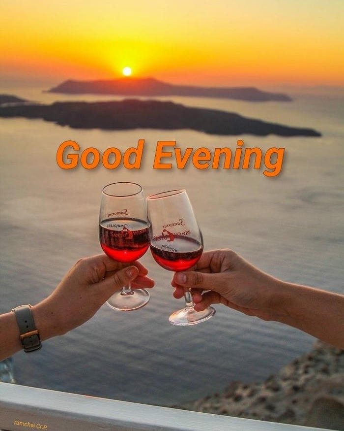 Two wine glasses toasting sunset ocean romantic evening view