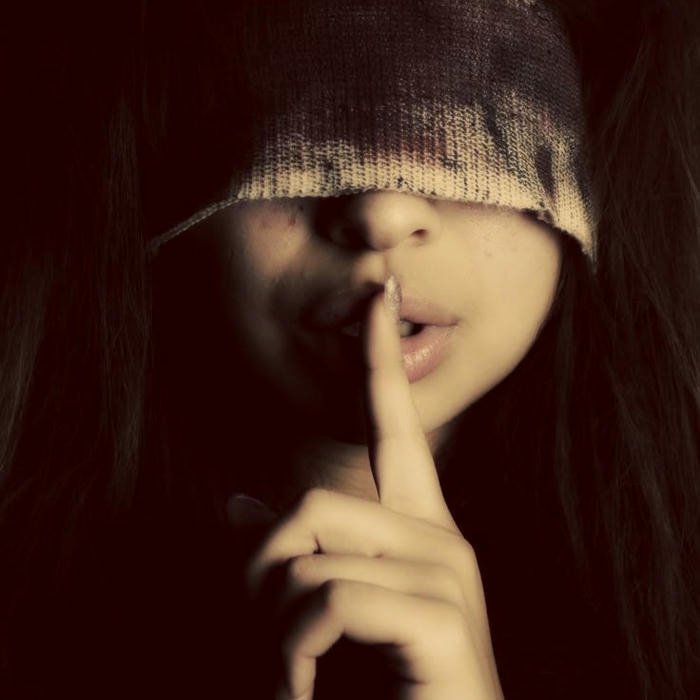 Artistic portrait person covering eyes finger on lips
