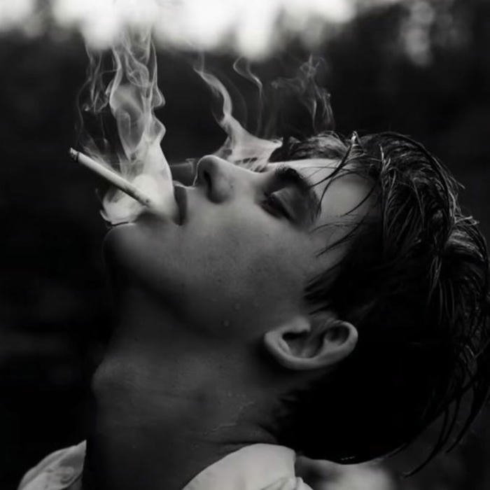 Black and white artistic photo man exhaling thick smoke