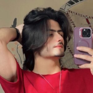 Casual boy red tshirt touching hair looking away