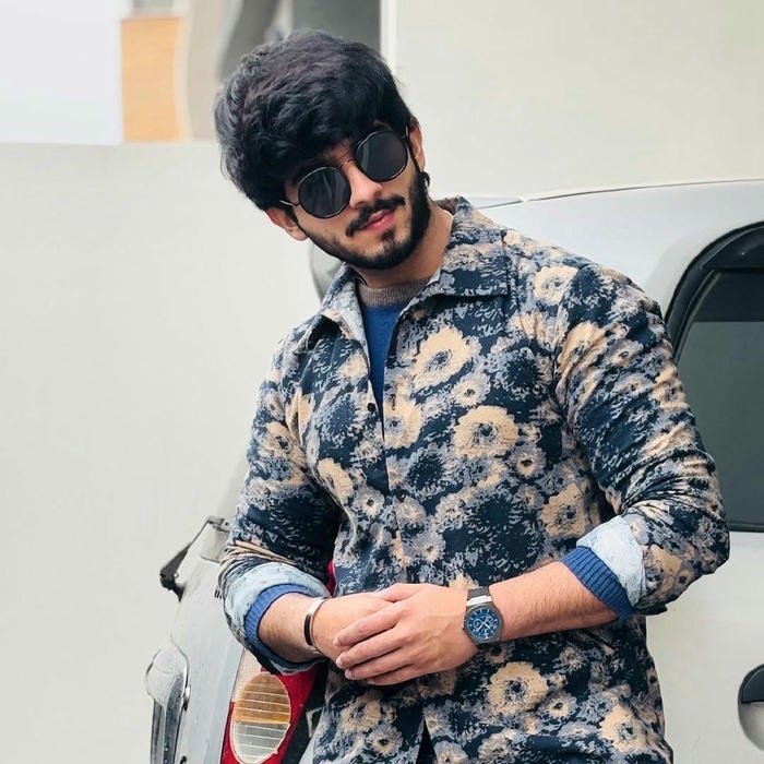 Classy man blue floral shirt adjusting sleeve watch