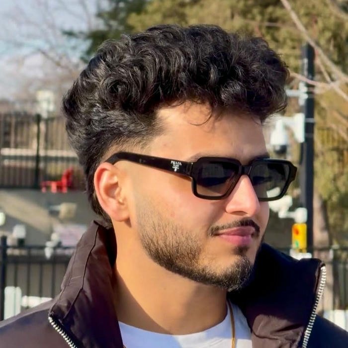 Cool boy with sunglasses looking sideways outdoors street style