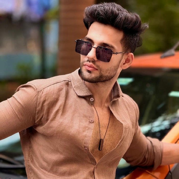 Fashionable man sunglasses brown shirt looking away outdoors