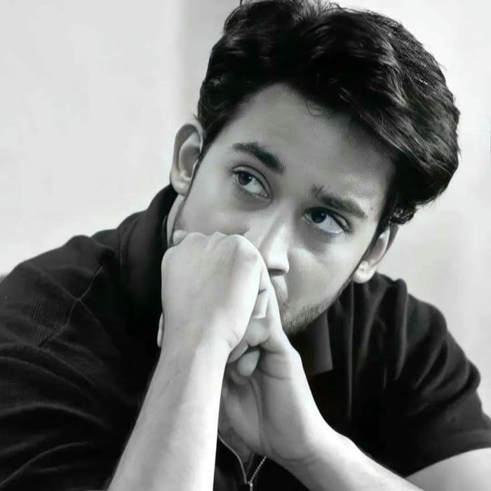 Handsome boy resting chin on hands looking very sad