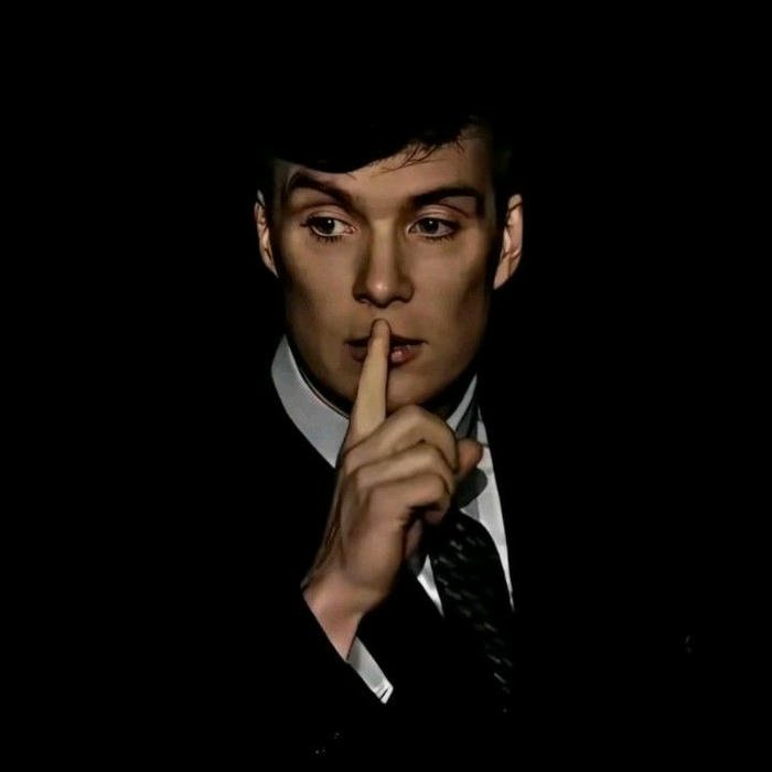 Handsome celebrity man in suit making shhh pose