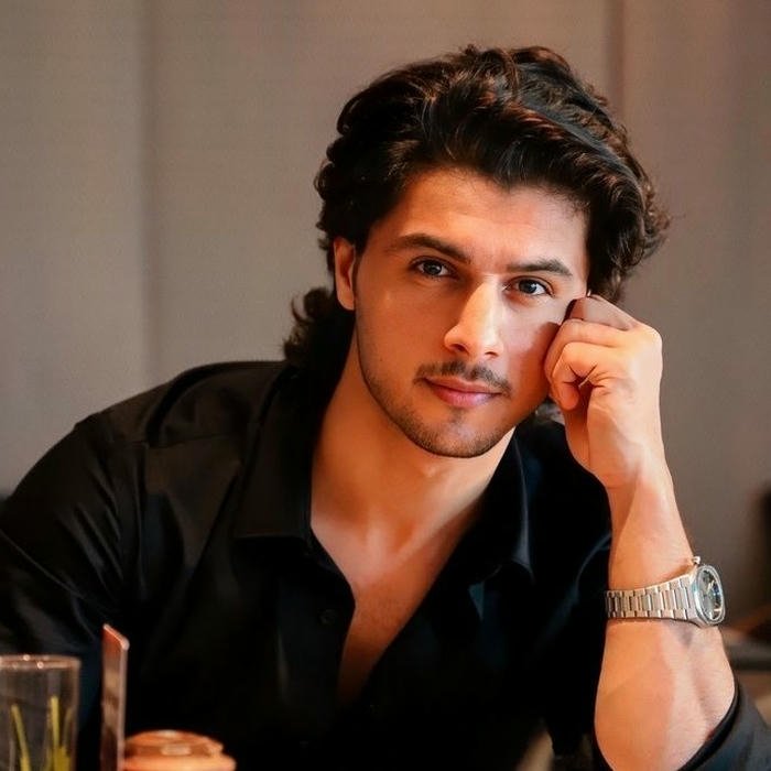 Intense look man black shirt leaning on hand