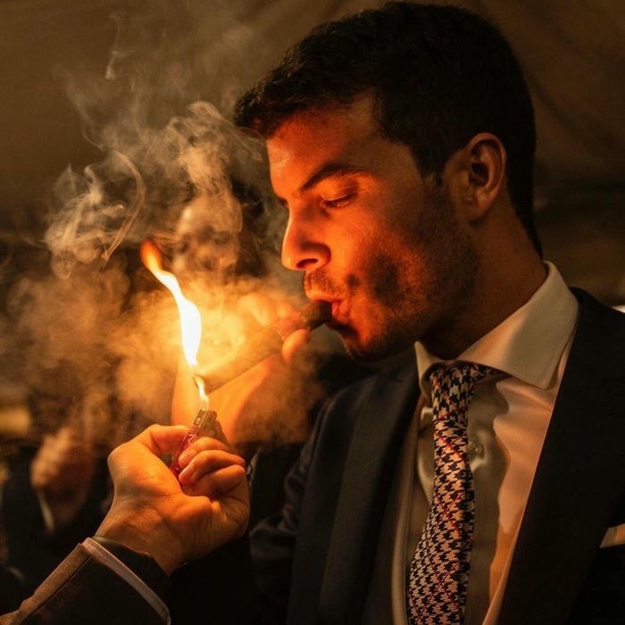Intense portrait man lighting cigarette with bright flame glow