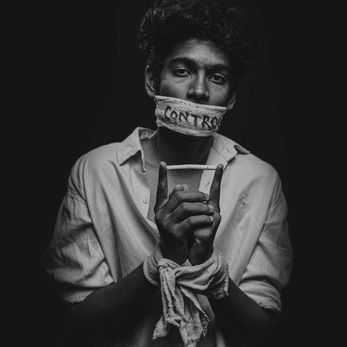 Man with taped mouth looking serious black and white