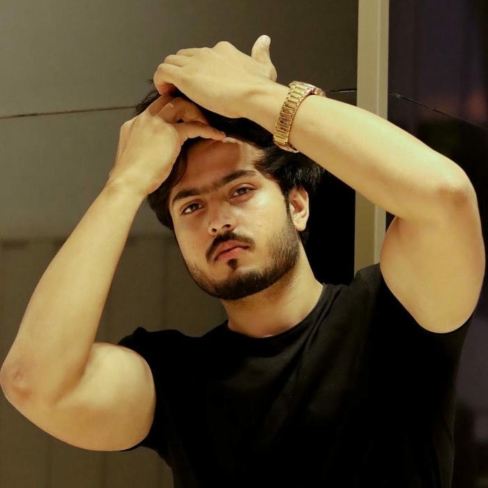 Muscular man posing with hand behind head showing biceps