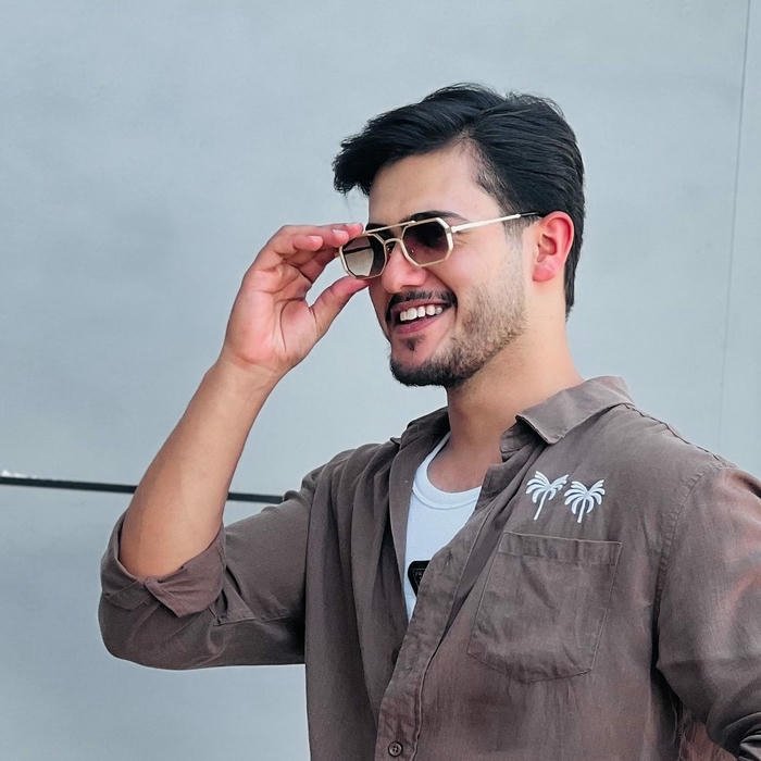 Smart boy dp smiling man holding sunglasses brown shirt