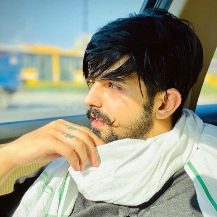 Stylish boy with white scarf draped around neck outdoors